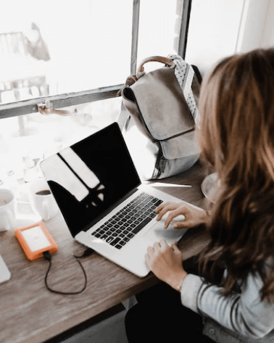 Girl wearing long sleeve shirt looking at laptop