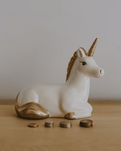 unicorn ceramic with coins on a table